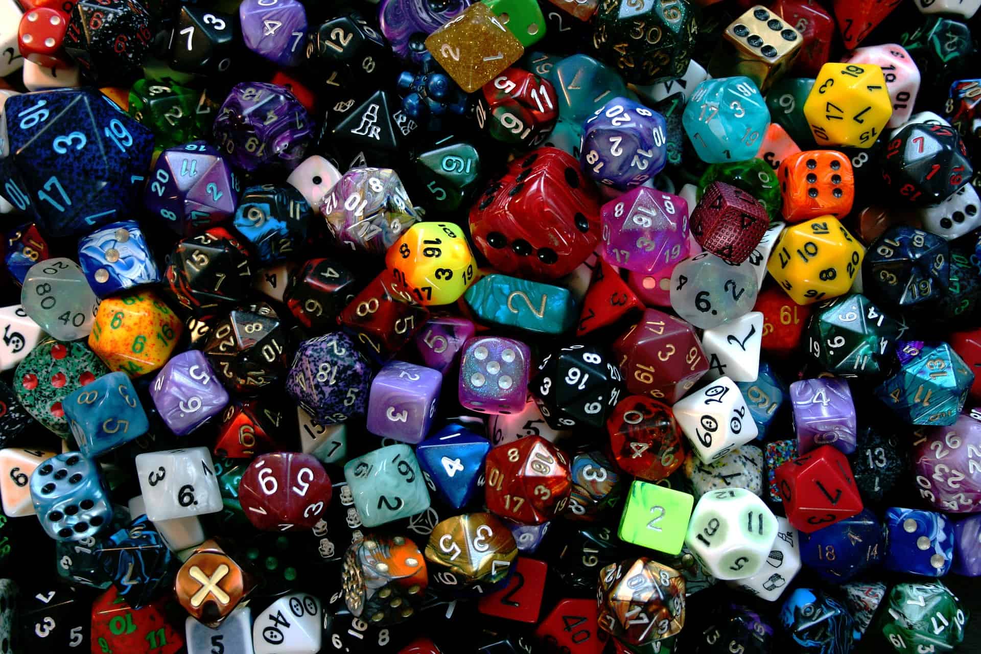 Vários dados de jogos de rpg de cores diferentes em uma mesa